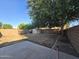 Large backyard with concrete patio, brick wall, shed, and partial lawn at 1309 E Julie Ct, San Tan Valley, AZ 85140
