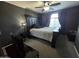 Dark bedroom with a ceiling fan, large window and a dark wood bedroom set at 1309 E Julie Ct, San Tan Valley, AZ 85140
