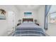 Inviting bedroom featuring a striped bedspread, coordinated lamps, and a relaxing beach themed painting at 14870 W Encanto Blvd # 1059, Goodyear, AZ 85395