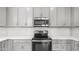 Modern kitchen featuring stainless steel microwave and electric stove complemented by grey cabinets at 14870 W Encanto Blvd # 1059, Goodyear, AZ 85395