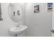 Bright powder room with pedestal sink, round mirror, and tropical themed artwork at 14870 W Encanto Blvd # 1059, Goodyear, AZ 85395