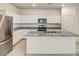 Bright kitchen with white cabinets, stainless steel appliances, and granite countertops on a spacious island at 15508 W Corte Del Sol Este --, Waddell, AZ 85355