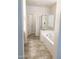 Bright bathroom offering a soaking tub, glass-enclosed shower, and modern tile flooring at 16526 W Calle Lejos --, Surprise, AZ 85387