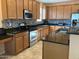 Well-lit kitchen features stainless steel appliances, granite countertops, stylish mosaic tile backsplash and tile flooring at 16526 W Calle Lejos --, Surprise, AZ 85387