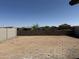 Large, undeveloped backyard with block wall and views of neighboring houses at 18243 W La Senda Dr, Surprise, AZ 85387