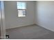 Cozy bedroom with neutral carpet, a bright window, and fresh, white walls at 18243 W La Senda Dr, Surprise, AZ 85387