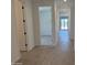 Bright hallway showcasing wood-look tile flooring leading to an airy room with sliding glass doors at 18243 W La Senda Dr, Surprise, AZ 85387