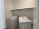 Functional laundry room with white washer and dryer and convenient shelving at 18243 W La Senda Dr, Surprise, AZ 85387