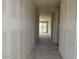 A hallway with gray walls and concrete floor leads to a room with sliding glass doors at 18260 W Camino De Oro --, Surprise, AZ 85387