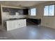 Bright kitchen area featuring dark cabinets, a kitchen island, and natural light with plastic on the floor at 18261 W Camino De Oro --, Surprise, AZ 85387
