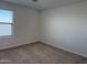 Well-lit room features neutral carpet and a window providing natural light at 18265 W La Senda Dr, Surprise, AZ 85387