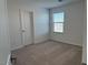 Bedroom featuring neutral carpet, window with blinds, white walls, and interior door at 18265 W La Senda Dr, Surprise, AZ 85387