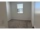 A simple bedroom with neutral carpet, white paint, and a window at 18265 W La Senda Dr, Surprise, AZ 85387