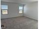 Bedroom featuring neutral carpeting and bright natural lighting through multiple windows at 18265 W La Senda Dr, Surprise, AZ 85387