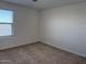 Bedroom featuring neutral carpet, window with blinds, and white walls at 18265 W La Senda Dr, Surprise, AZ 85387