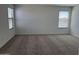 Bedroom featuring neutral carpet, two windows with blinds, and white walls at 18265 W La Senda Dr, Surprise, AZ 85387