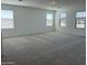 Large bonus room with neutral carpet, white walls, and three windows providing plenty of natural light at 18265 W La Senda Dr, Surprise, AZ 85387