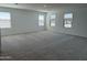 Spacious bonus room with soft, neutral carpeting and multiple windows for plenty of natural light at 18265 W La Senda Dr, Surprise, AZ 85387