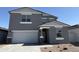 Charming two-story home with a two-car garage, stucco facade, and low maintenance front yard at 18265 W La Senda Dr, Surprise, AZ 85387
