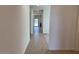 Bright hallway with wood-look tile flooring leading to the kitchen and a sliding glass door at 18265 W La Senda Dr, Surprise, AZ 85387