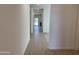 Bright hallway featuring ceramic wood-look tiling and neutral paint at 18265 W La Senda Dr, Surprise, AZ 85387