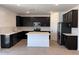 Stylish kitchen with dark cabinetry, stainless steel appliances, a center island, and tile backsplash at 18265 W La Senda Dr, Surprise, AZ 85387