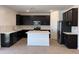 Modern kitchen with stainless steel appliances, center island, and dark wood cabinets at 18265 W La Senda Dr, Surprise, AZ 85387