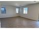 Open-concept living room with wood-look tile flooring, large windows and a sliding glass door at 18265 W La Senda Dr, Surprise, AZ 85387