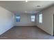 Spacious living room featuring wood-look tile flooring and large windows for natural light at 18265 W La Senda Dr, Surprise, AZ 85387