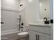 Bright bathroom featuring white fixtures, shower-tub combo, and modern black hardware at 18271 W La Senda Dr, Surprise, AZ 85387