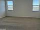 Spacious bedroom featuring neutral carpet and two windows with blinds providing ample sunlight at 18271 W La Senda Dr, Surprise, AZ 85387
