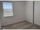 Neutral carpeted bedroom featuring a window with blinds and closet at 18271 W La Senda Dr, Surprise, AZ 85387