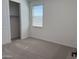 Cozy bedroom with neutral carpet, a window with blinds, and a closet at 18271 W La Senda Dr, Surprise, AZ 85387