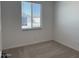 A cozy bedroom with neutral carpet and a bright window at 18271 W La Senda Dr, Surprise, AZ 85387