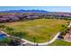 Includes a vast open green field for recreational use, bordered by walking paths and landscaping at 18271 W La Senda Dr, Surprise, AZ 85387