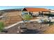 Features a covered playground with slides and picnic tables in a community park with natural landscaping at 18271 W La Senda Dr, Surprise, AZ 85387