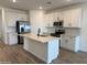 Spacious kitchen with white cabinets, a large island, and stainless steel appliances at 18271 W La Senda Dr, Surprise, AZ 85387