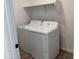 Laundry room with standard-sized washing machine and dryer and a white storage shelf at 18271 W La Senda Dr, Surprise, AZ 85387