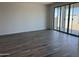 Bright living room featuring wood tile flooring and sliding glass doors to the backyard at 18271 W La Senda Dr, Surprise, AZ 85387
