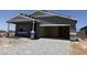 This home's exterior features a covered porch, a two-car garage, and desert landscaping at 18272 W Camino De Oro --, Surprise, AZ 85387