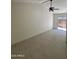 Bright living room featuring neutral walls, tile floors, ceiling fan, and sliding glass door at 18629 N 4Th Dr, Phoenix, AZ 85027