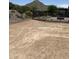 The future backyard space with desert landscaping, black iron fence, and mountain views at 18717 N 267Th Dr, Buckeye, AZ 85396