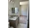 Bathroom vanity with marble countertop, access to the restroom, and adjoining bedroom at 18717 N 267Th Dr, Buckeye, AZ 85396