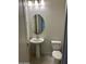 Cozy bathroom with a pedestal sink, an oval mirror, neutral color palette and a low-flow toilet at 18717 N 267Th Dr, Buckeye, AZ 85396
