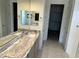 Bathroom with double vanity, a marble countertop, large mirrors, and access to a walk-in closet at 18717 N 267Th Dr, Buckeye, AZ 85396