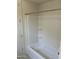 Clean white bathtub and shower with built in shelving and contemporary hardware at 18717 N 267Th Dr, Buckeye, AZ 85396