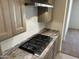 Modern cooktop with granite counters and updated kitchen cabinets at 18717 N 267Th Dr, Buckeye, AZ 85396