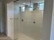 Bright shower featuring tile walls, glass enclosure, multiple shower heads and transom windows at 18717 N 267Th Dr, Buckeye, AZ 85396