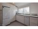 Modern kitchen features sleek white cabinetry, granite countertops, and stainless steel appliances with natural lighting at 1950 W Palm Ln, Phoenix, AZ 85009