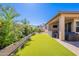 Green artificial turf and a covered patio, perfect for outdoor gatherings and relaxation at 20641 W College Dr, Buckeye, AZ 85396